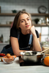 Young woman in kitchen. Beautiful woman making delicious food