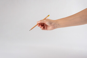 Hand and wooden pencil on a white background