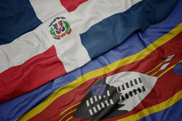 waving colorful flag of swaziland and national flag of dominican republic.