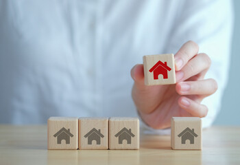 Real estate. House. Property investment and asset management. home loan, tax, mortgage, buy, rent. Hand choosing house on wooden block from many house. choose the best property.