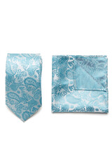 Close-up set of a turquoise and white tie and pocket square embossed with a floral paisley pattern. The paisley tie and pocket square are isolated on a white background. Top view.