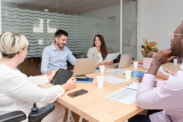 group of young corporate people working together in a boardroom on a marketing project