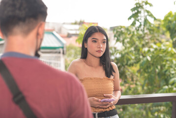 A female teenager puts on a straight face as she is being confronted by her boyfriend about their...
