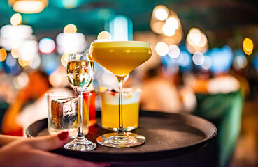glasses alcohol cocktail set on a waiter tray in bar