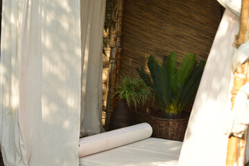 White bed in a bungalow with flowers and white curtains