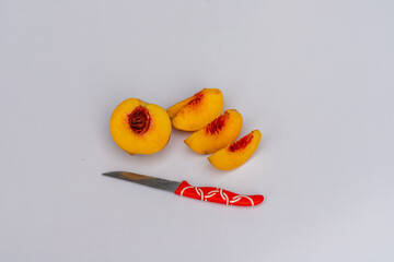 Ripe peach fruit sliced on a white background