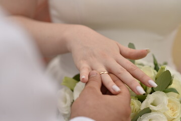 The groom puts on the bride an engagement ring at the wedding