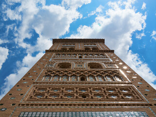 Mudejar Tower of San Martin in Teruel with blue sky and white clouds, Spain