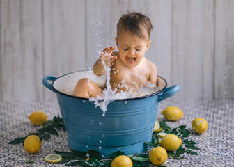 Baby splash water while bath in milk with fruit