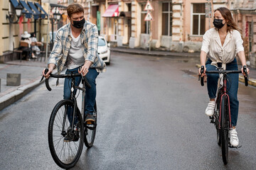 Caucasian couple wear medical masks ride bicycles