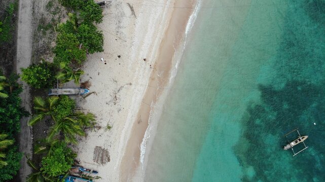 Aerial view of the turquoise bay with boats. Baucau, East Timor.