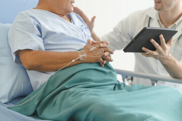 happy asian elderly looking at a good result of health check up in the medical chart with doctor.