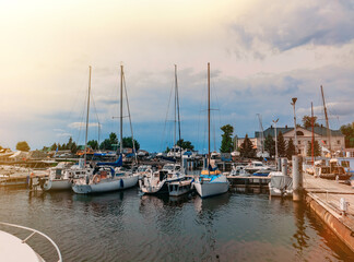 Fototapeta na wymiar Boats and sailboats moored to a pier in a yacht marina.