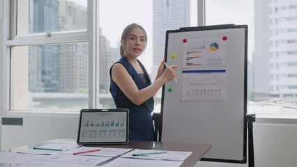 Young smiling business woman presenting infographic chart via video conference by tablet at home office on city background.wireless technology,6G,AR,Online meeting and Working remotely at home concept - Powered by Adobe