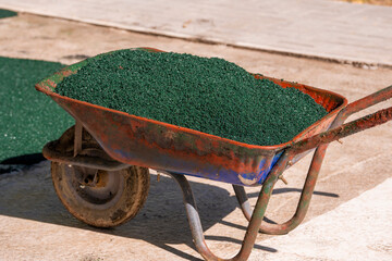 Trolley filled with crumb rubber obtained in the process of recycling used car tires to cover the...