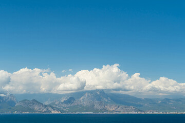 A coastal town at the foot of the mountains and the sea. Clouds in the mountains