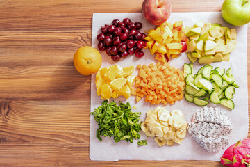Sliced fruits and vegetables for smoothies. Cherry, orange and apple. Top view