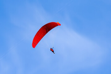 Paragliding in flight. Red and orange paraglider.