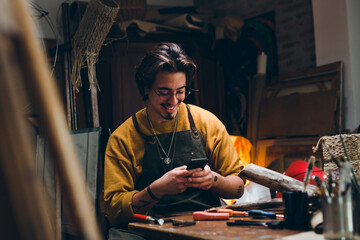 craft man using smart phone  his workshop