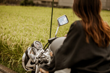 バイクに乗る女性の後ろ姿 