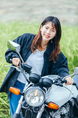 Obraz na płótnie Canvas 日本人女性が笑顔でバイクに乗る