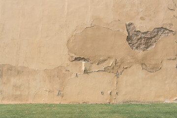 Background of old cracked concrete wall over green grass outdoor