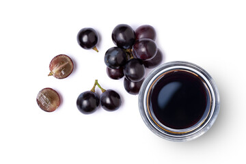 Black grapes and grape molasses in glass bowl isolated on white background, Top view, flat lay.