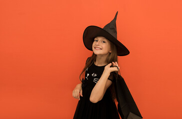 Portrait of a cute attractive fairy girl holding shopping bags on an orange background, Halloween sale, girl shopping for Halloween,