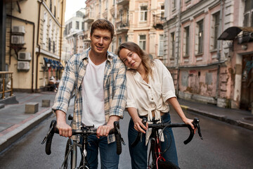 Young couple with bicycles looking at camera