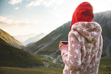 Back view thoughtful female caucasian in pyjamas stand on viewpoint drink fresh coffee in nature...