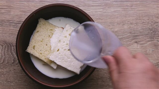 Pieces of bread soaked in milk in a deep bowl.