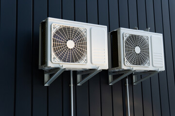 Air conditioner compressor on a dark wall.