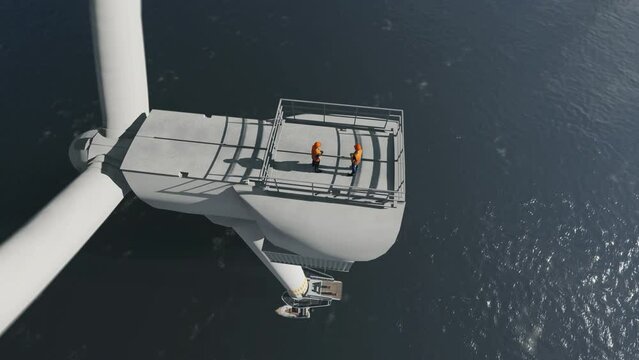 Workers on top of an offshore wind turbine, 4K