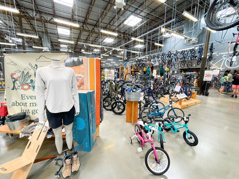 Bike racks with wide collection of bicycles for adults and kids inside REI (Recreational Equipment, Inc) store