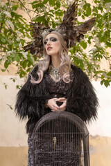 Girl in a fantastic image with a birdcage. bird queen.