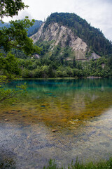 Fototapeta na wymiar Lake with submerged tree trunks. Jiuzhaigou Valley was recognize by UNESCO as a World Heritage Site and a World Biosphere Reserve - China. soft focus image