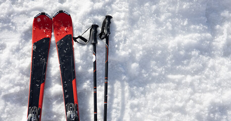 Mountain skis and ski sticks on bright alpine snow. Winter holidays. Extreme sport. Vacation, travel content. Copy space