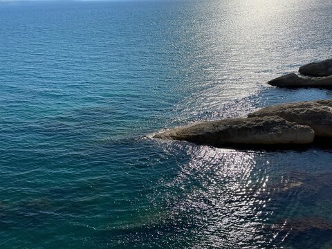 Sea shiny blue turquoise water and scenic coastal rocks.