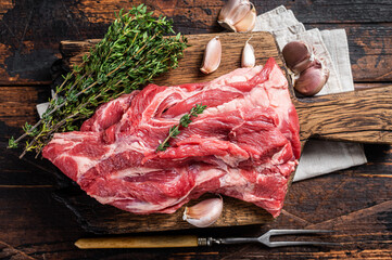 Raw Boneless lamb meat, raw neck meat on wooden board. Black background. Top view