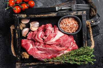 Lamb or mutton neck meat, raw Boneless meat in wooden tray. Black background. Top view