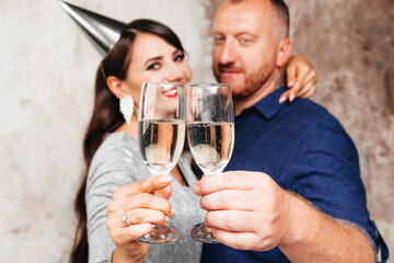 Funny man and woman with hats on their heads ,a festive party with champagne lifestyle party. the couple celebrates a birthday or new year.