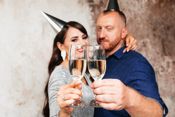 Funny man and woman with hats on their heads ,a festive party with champagne lifestyle party. the couple celebrates a birthday or new year.