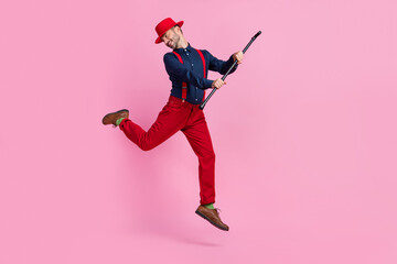 Full length photo of overjoyed cheerful person arms hold stick jumping isolated on pink color background