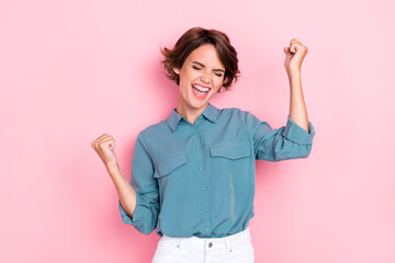 Photo portrait of pretty young girl raise fists screaming yeah job promotion dressed trendy blue garment isolated on pink color background