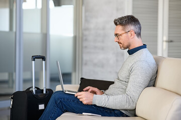 Absorbed businessman working on laptop at airport