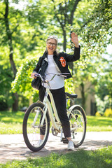 Mature woman on a bike in a summer park