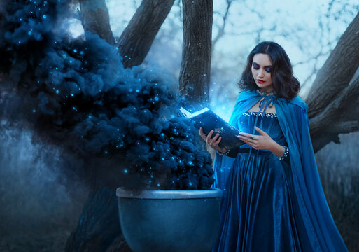 Halloween concept fantasy woman witch conjures, holds book in hands reads spell black magic smoke from boiling vat. Gothic sexy girl. Blue creative design dress cape. Forest trees dark autumn nature
