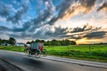 Amish Buggy on Rural Indiana road at sunrise. - obrazy, fototapety, plakaty