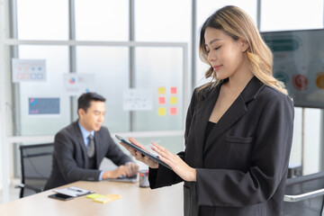 Asian businesswomen looking at the camera Working and meeting at the office at the company with colleagues at the back