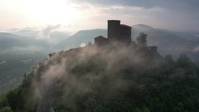 Beautiful view of the Trifels Castle on the peak of a hill surrounded by trees under a cloudy sky